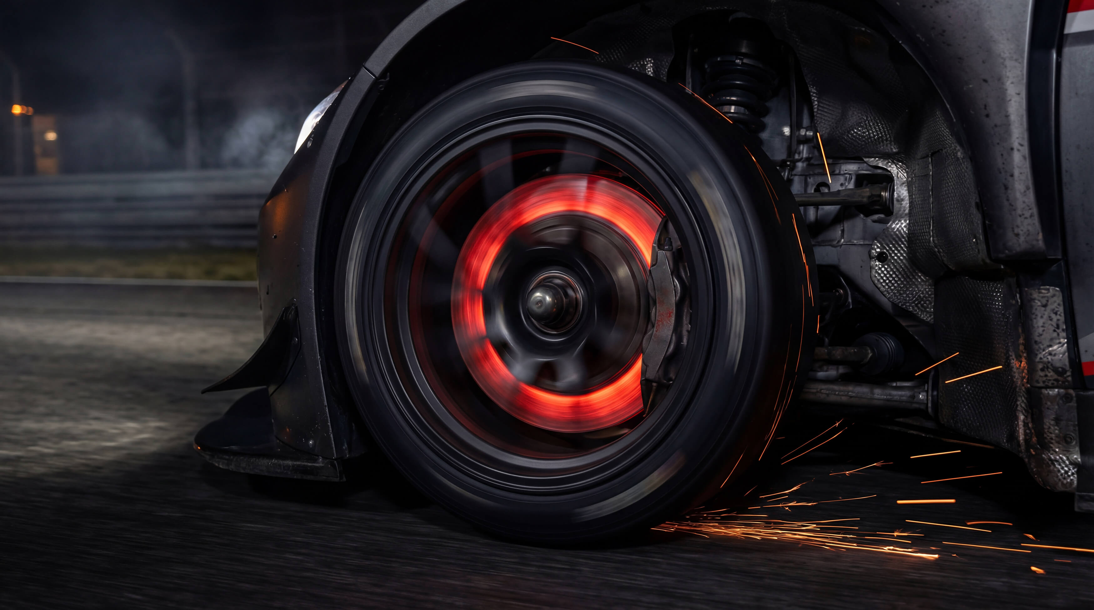 Close-up of carbon ceramic brake rotors glowing red hot during extreme track testing